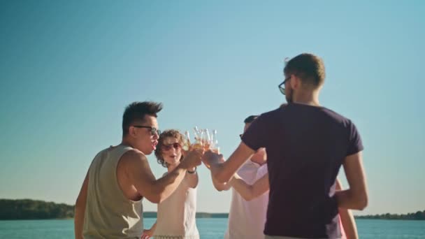 Jóvenes golpeando botellas en la playa — Vídeo de stock