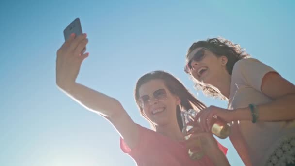 Zwei junge Damen machen ein Selfie am Strand — Stockvideo