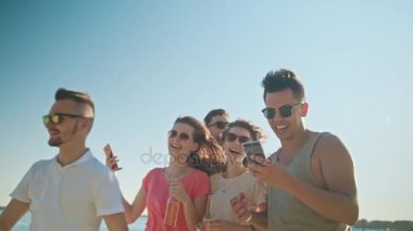 Gençler eğleniyor telefonları kullanarak sahilde