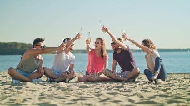 Jóvenes golpeando botellas en la playa — Vídeo de stock