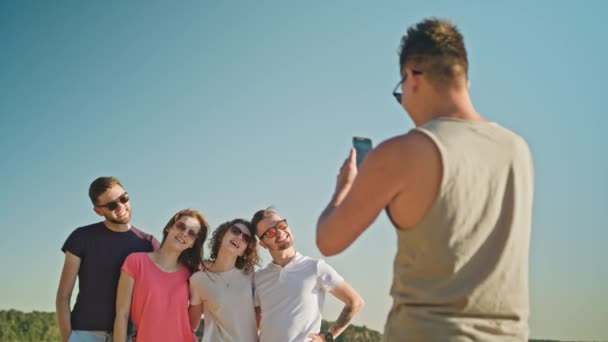 Fiatalok pózol egy fotó a strandon — Stock videók