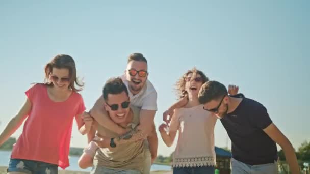 Junge Leute amüsieren sich am Strand — Stockvideo