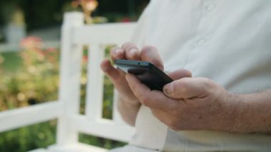 Yaşlı adam açık havada bir telefon kullanma