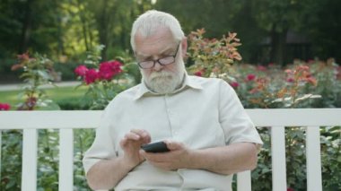 Yaşlı adam açık havada bir telefon kullanma
