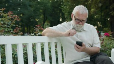 Yaşlı adam açık havada bir telefon kullanma