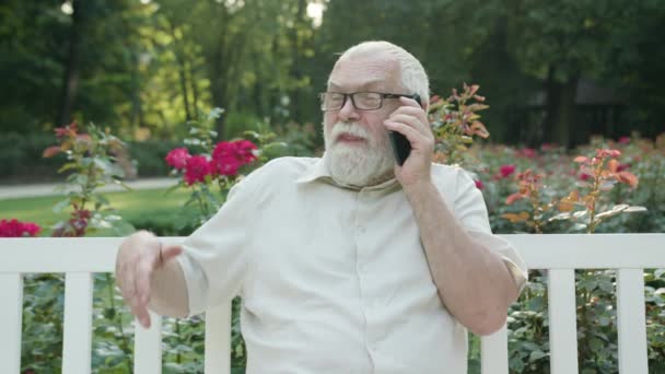 Velho falando ao telefone ao ar livre — Vídeo de Stock