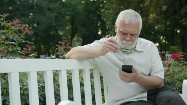 Velho usando um telefone ao ar livre — Vídeo de Stock