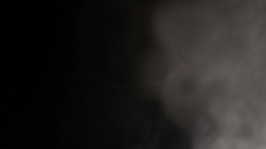 Soyut beyaz su buharı siyah bir zemin üzerine.