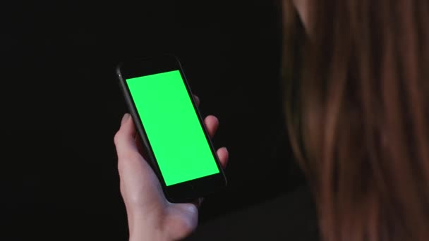 Vrouw is Holding telefoon met groene scherm vegen — Stockvideo