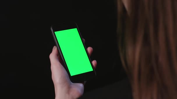 Femme tient le téléphone avec défilement d'écran vert 