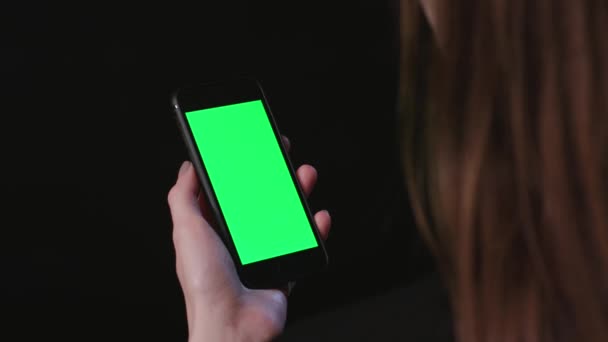 Vrouw is Holding telefoon met groene scherm Scroll — Stockvideo