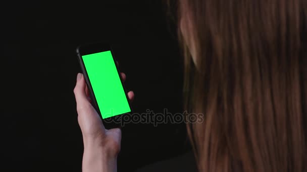 Женщина держит телефон с зеленым экраном — стоковое видео