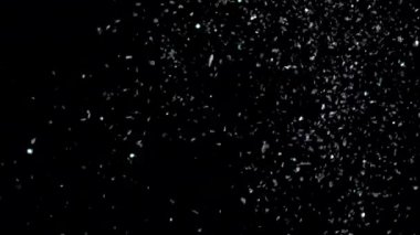 Siyah arka plan üzerinde patlayan gerçekçi Glitter.