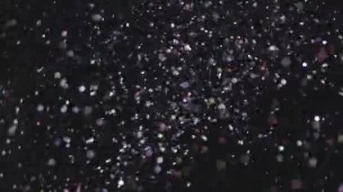 Siyah arka plan üzerinde patlayan gerçekçi Glitter.