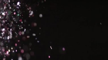 Siyah arka plan üzerinde patlayan gerçekçi Glitter.