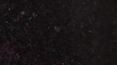 Siyah arka plan üzerinde patlayan gerçekçi Glitter.