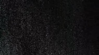 Siyah arka plan üzerinde patlayan gerçekçi Glitter.