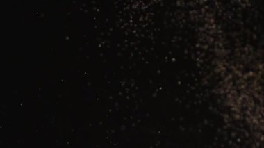 Siyah arka plan üzerinde patlayan gerçekçi Glitter.