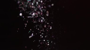 Siyah arka plan üzerinde patlayan gerçekçi Glitter.