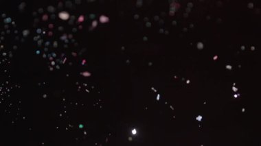 Siyah arka plan üzerinde patlayan gerçekçi Glitter.