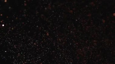 Siyah arka plan üzerinde patlayan gerçekçi Glitter.