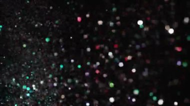 Siyah arka plan üzerinde patlayan gerçekçi Glitter.
