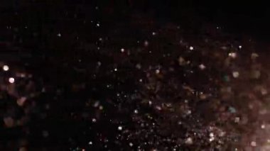 Siyah arka plan üzerinde patlayan gerçekçi Glitter.