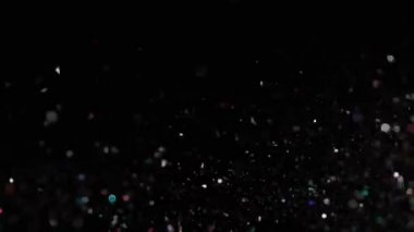 Siyah arka plan üzerinde patlayan gerçekçi Glitter.