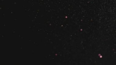 Siyah arka plan üzerinde patlayan gerçekçi Glitter.