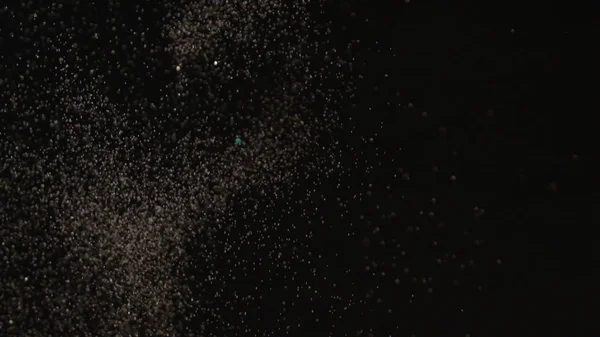 Realistic Glitter Exploding on Black Background.