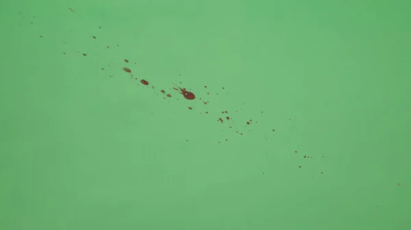 Roter Tintenklecks auf grünem Bildschirmhintergrund — Stockfoto