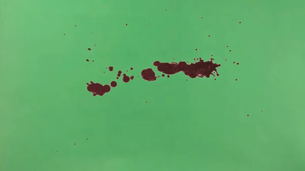Red Ink Splatter Over Green Screen Background