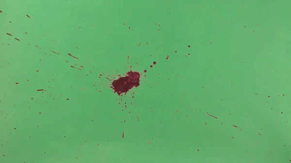 Red Ink Splatter Over Green Screen Background — Stock Photo, Image