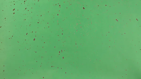 Rote Tinte über grünen Bildschirmhintergrund gestreut — Stockfoto