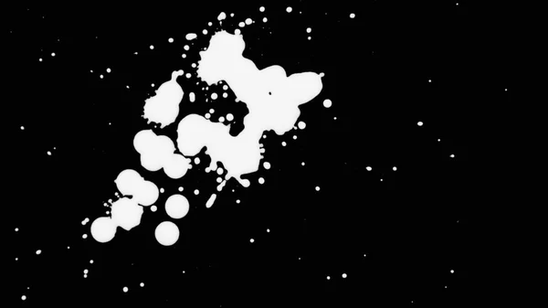 Λευκό μελάνι πιτσιλίσματα πάνω από μαύρη οθόνη υποβάθρου — Φωτογραφία Αρχείου