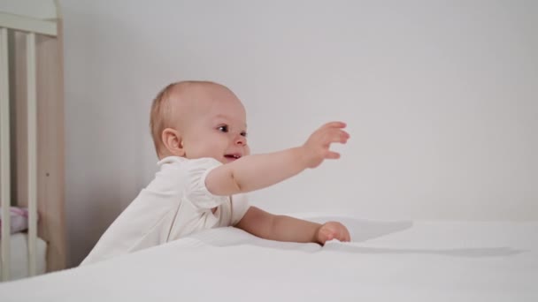 Младенец, стоящий у кровати дома — стоковое видео