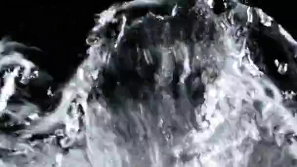 Víz ömlött a makró felvételek. Fekete háttér — Stock videók