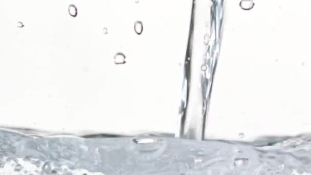 Víz ömlött a makró felvételek. Fehér háttér — Stock videók