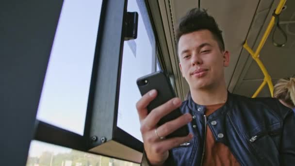 Mladý muž pomocí Smartphone na sběrnici — Stock video