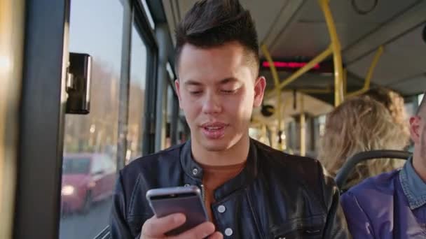 Un joven usando un teléfono inteligente en el autobús — Vídeos de Stock