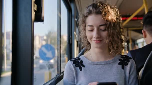 Seorang wanita muda menggunakan Smartphone di bus — Stok Video