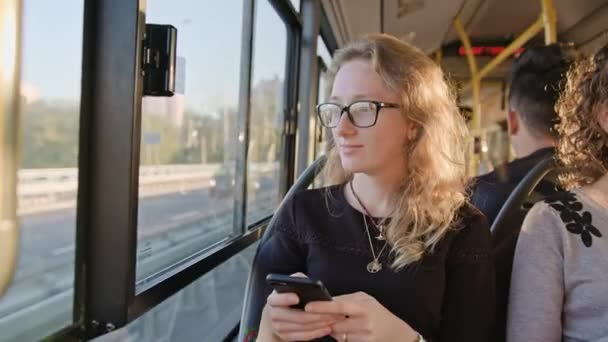 Una joven usando un teléfono inteligente en el autobús — Vídeo de stock
