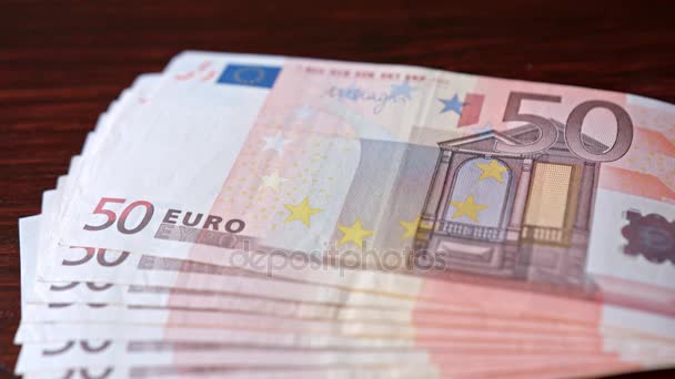 Aufgefächerter Stapel Fünfzig-Euro-Scheine auf einem Tisch — Stockvideo