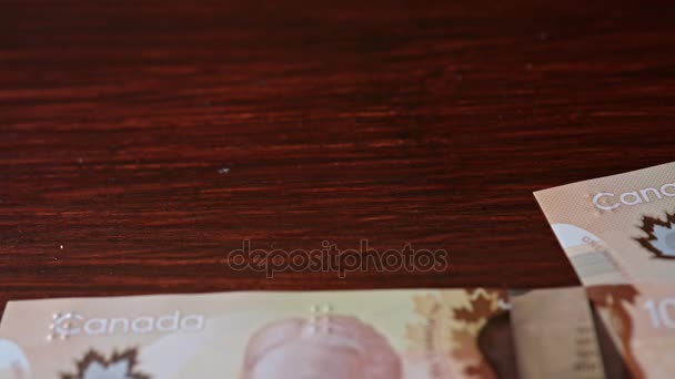 Заборонена купа стодоларових банкнот на столі — стокове відео