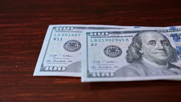 Куча банкнот на сто долларов на столе — стоковое видео