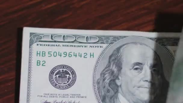 Montón de billetes de cien dólares en una mesa — Vídeo de stock