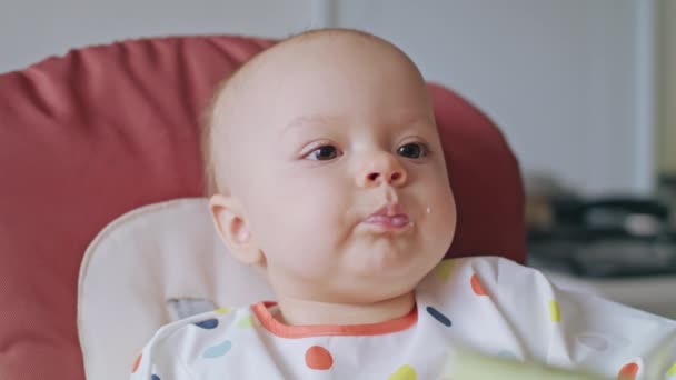 Een meisje van de Baby eten Puree thuis — Stockvideo