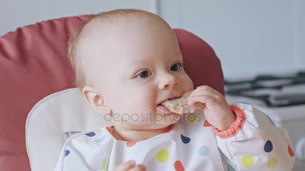 Маленькая девочка ест хлеб дома — стоковое видео