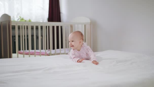Baby krabbelt auf allen Vieren auf dem Bett — Stockvideo