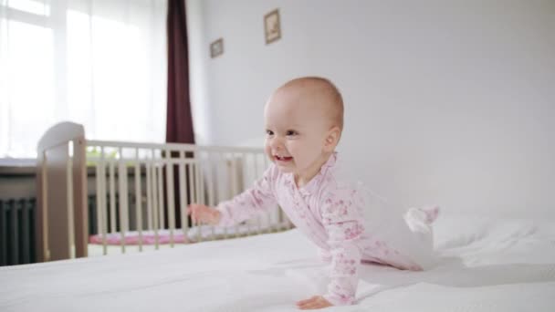 Bebé arrastrándose a cuatro patas en la cama — Vídeo de stock